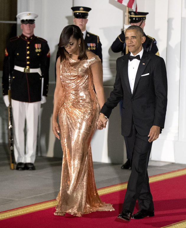 President Barack Obama and first lady Michelle Obama walk to North Portico at the White House to greet Italian Prime Minister Matteo Renzi and his wife Agnese Landini, for a State Dinner at the White House in Washington, Tuesday, Oct. 18, 2016. The first lady is wearing a floor length, rose gold chainmail gown designed by Atelier Versace. (AP Photo/Manuel Balce Ceneta)